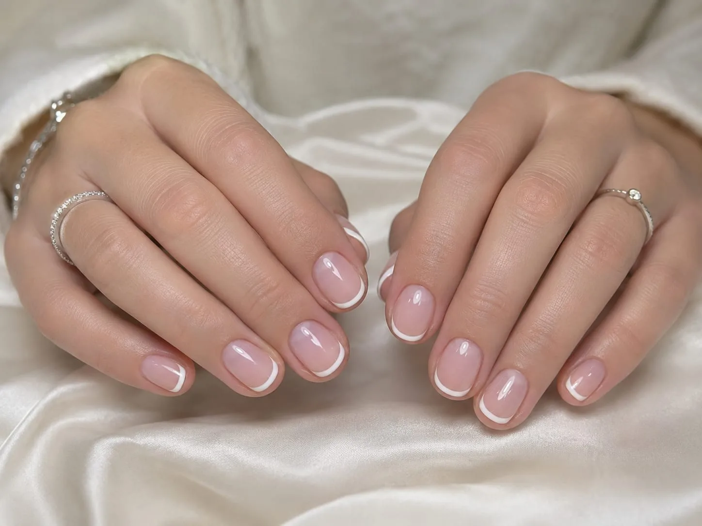 French manucure réalisée par Eva Révèle : ongles courts arrondis, base rosée nacrée et liseré blanc net