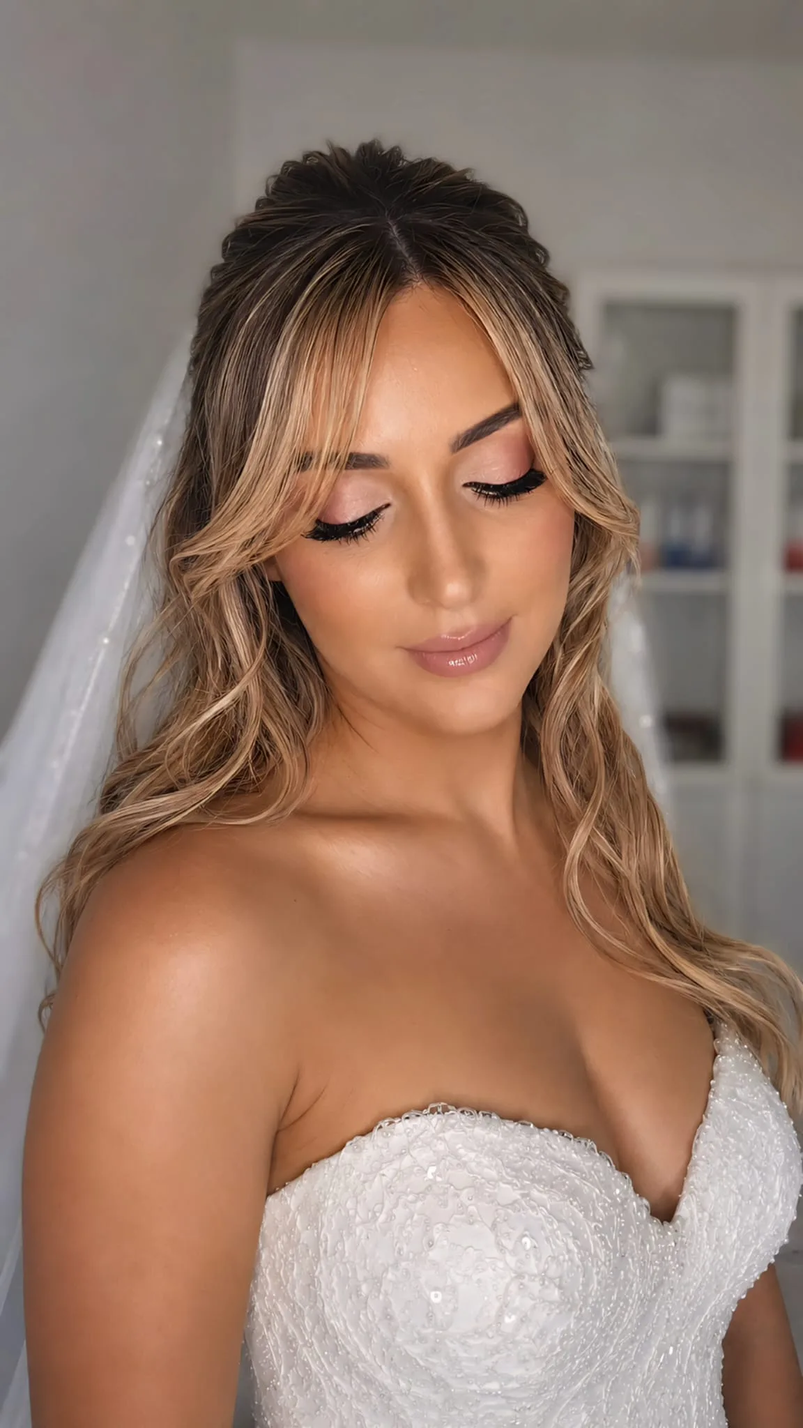 Maquillage de mariée réalisé par Eva Révèle : teint lumineux, regard rosé et bouche nude, avec voile